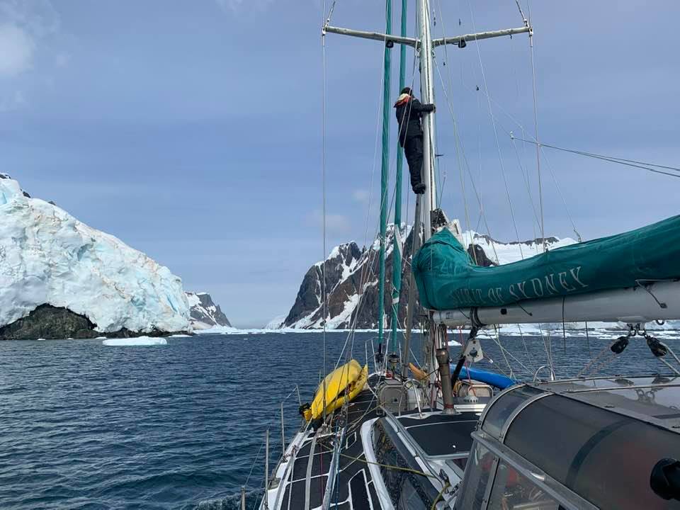 Adrien looking for a path through the Ice on the Lemaire Channel. Sailing in Antarctica.